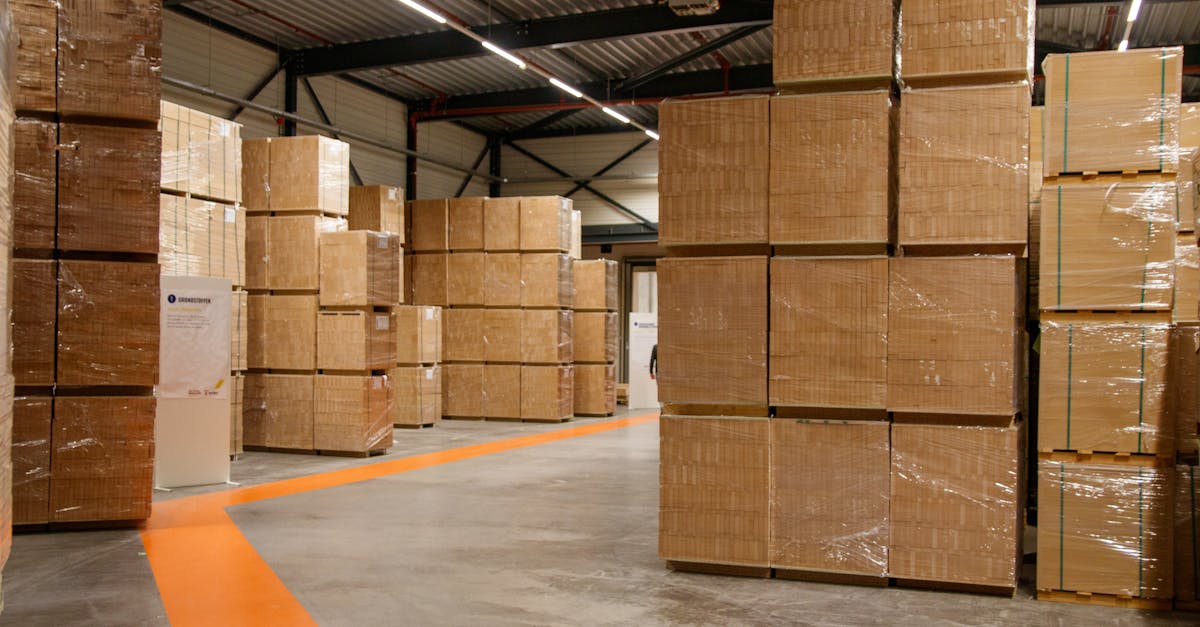 pexels-photo-34221998-34221998 A spacious industrial warehouse filled with stacked cardboard boxes for storage and shipping.